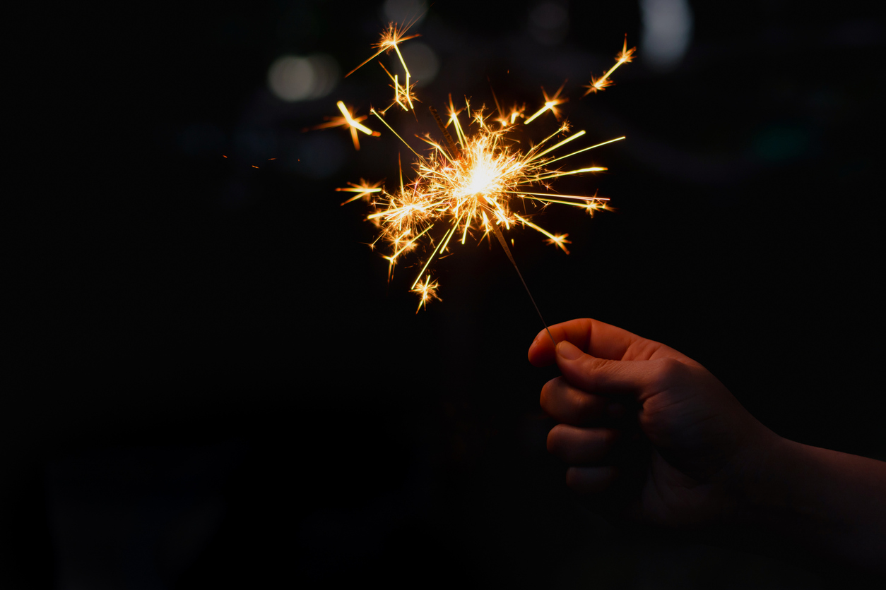 Cropped Hand Holding Sparkler At Night